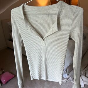 Cream, small, long sleeve with low V neck line.